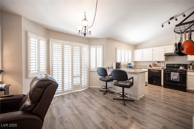 7231 Sequoia Springs Dr, Las Vegas, NV 89147 - kitchen with black appliances, a breakfast bar, light wood finished floors, a chandelier, and open floor plan
