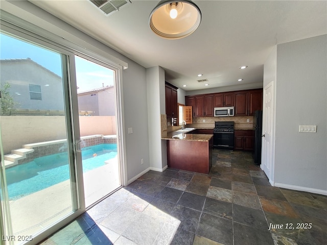 9530 Windsor Forest Ct, Las Vegas, NV 89123 - kitchen with black appliances, a peninsula, stone tile floors, decorative backsplash, and recessed lighting