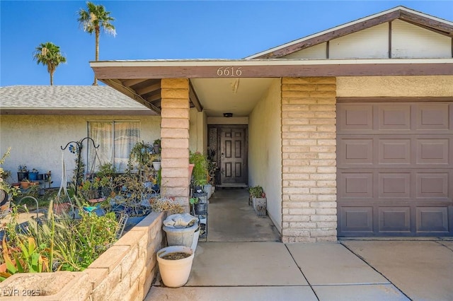 6616 Celeste Ave, Las Vegas, NV 89107 - doorway to property featuring brick siding, stucco siding, an attached garage, and driveway