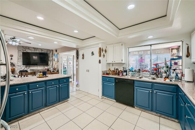 6616 Celeste Ave, Las Vegas, NV 89107 - kitchen featuring black dishwasher, a tray ceiling, blue cabinetry, ceiling fan, and light countertops