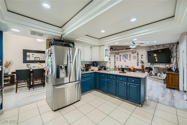 6616 Celeste Ave, Las Vegas, NV 89107 - kitchen featuring stainless steel fridge, a tray ceiling, blue cabinetry, a peninsula, and a ceiling fan