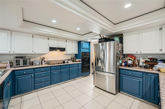 6616 Celeste Ave, Las Vegas, NV 89107 - kitchen featuring black appliances, a raised ceiling, blue cabinets, white cabinets, and under cabinet range hood