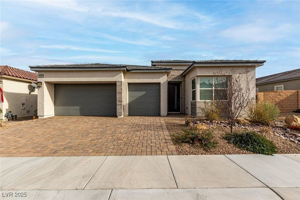8934 Windgate Ranch St, Las Vegas, NV 89166 - prairie-style home with an attached garage, decorative driveway, stucco siding, and a tiled roof