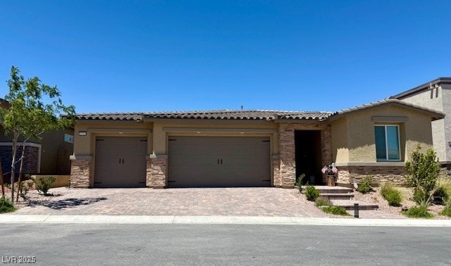 10904 Ellis Pointe Ave, Las Vegas, NV 89166 - ranch-style home with an attached garage, stone siding, decorative driveway, a tile roof, and stucco siding