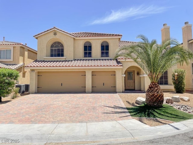 10052 Baystone St, Las Vegas, NV 89141 - mediterranean / spanish house with stucco siding, an attached garage, decorative driveway, and a tiled roof