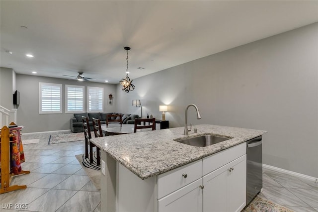 3166 Via Da Vinci, Henderson, NV 89044 - kitchen featuring open floor plan, stainless steel dishwasher, a kitchen island with sink, ceiling fan, and decorative light fixtures