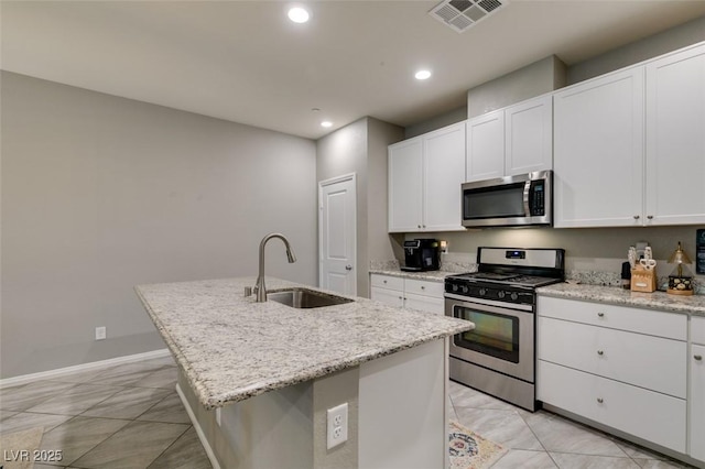 3166 Via Da Vinci, Henderson, NV 89044 - kitchen with stainless steel appliances, recessed lighting, a center island with sink, white cabinetry, and light stone counters