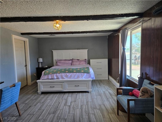 4823 El Tesoro Ave, Las Vegas, NV 89121 - bedroom featuring light wood-style floors, a textured ceiling, and wood walls