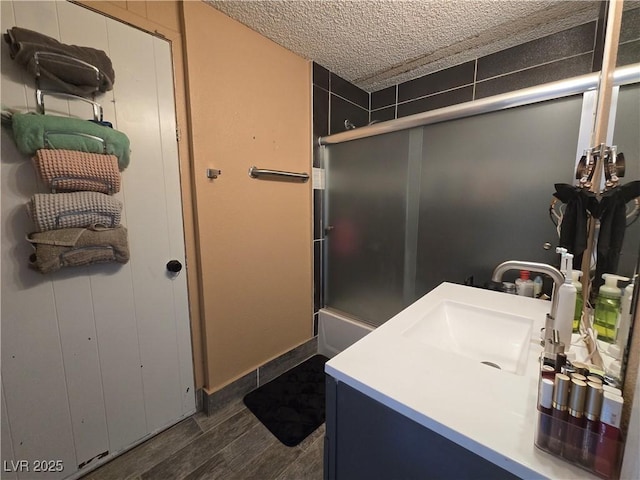 4823 El Tesoro Ave, Las Vegas, NV 89121 - full bathroom with vanity, a textured ceiling, wood finished floors, and shower / bath combination with glass door