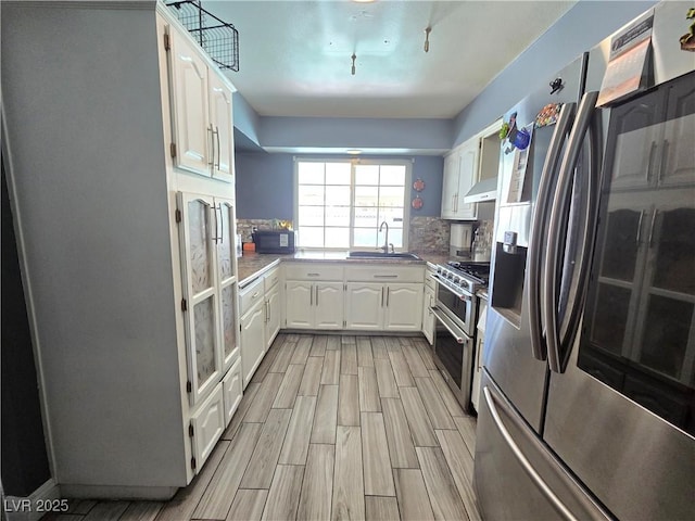 4823 El Tesoro Ave, Las Vegas, NV 89121 - kitchen featuring stainless steel appliances, white cabinets, wood finish floors, and backsplash