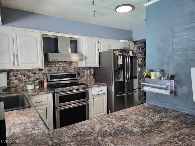 4823 El Tesoro Ave, Las Vegas, NV 89121 - kitchen featuring stainless steel appliances, wall chimney range hood, tasteful backsplash, white cabinetry, and dark stone countertops