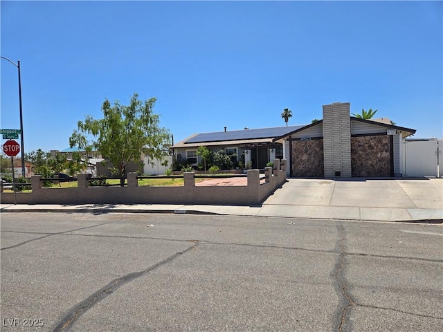 4823 El Tesoro Ave, Las Vegas, NV 89121 - view of front facade featuring a fenced front yard, driveway, roof mounted solar panels, an attached garage, and a gate