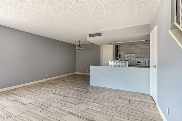 1372 Lorilyn Ave Unit 3, Las Vegas, NV 89119 - empty room with a chandelier and a textured ceiling