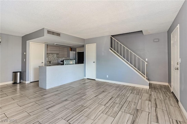 1372 Lorilyn Ave Unit 3, Las Vegas, NV 89119 - unfurnished living room with stairs, wood finish floors, and a textured ceiling