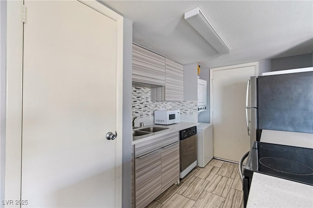 1372 Lorilyn Ave Unit 3, Las Vegas, NV 89119 - kitchen with appliances with stainless steel finishes, light countertops, backsplash, and estacked washer and dryer