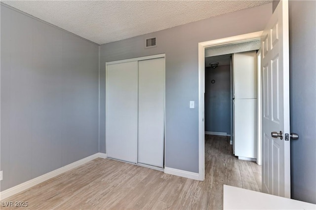 1372 Lorilyn Ave Unit 3, Las Vegas, NV 89119 - unfurnished bedroom with wood finished floors, a closet, and a textured ceiling