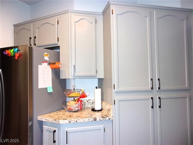 3337 Partridge Run St, Laughlin, NV 89029 - kitchen featuring freestanding refrigerator and light stone countertops