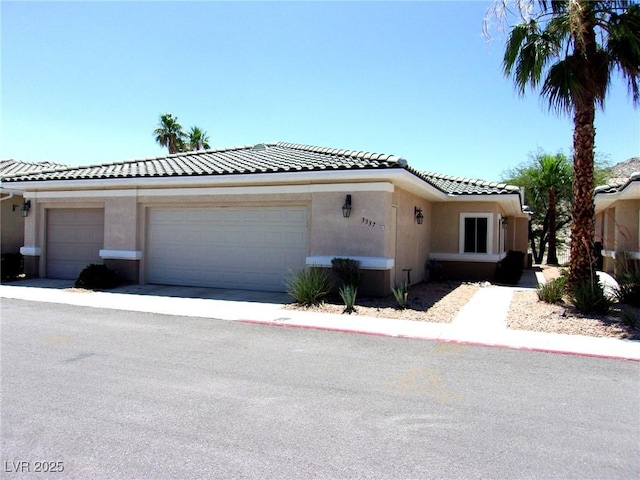 3337 Partridge Run St, Laughlin, NV 89029 - view of front of property featuring a tiled roof, stucco siding, an attached garage, and driveway