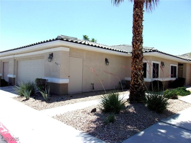 3337 Partridge Run St, Laughlin, NV 89029 - view of side of property featuring stucco siding, a tiled roof, and an attached garage