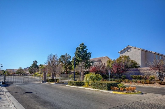 8768 Tom Noon Ave Unit 101, Las Vegas, NV 89178 - view of asphalt road with a gated entry, curbs, and a gate