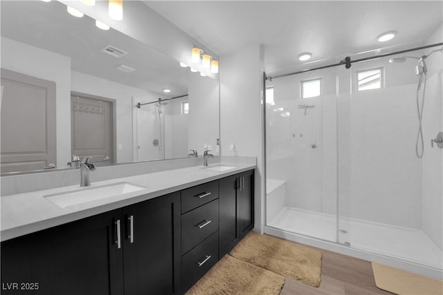 8072 Haywood Estate Ave, Las Vegas, NV 89113 - bathroom featuring a shower stall, double vanity, and wood finished floors
