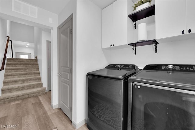 8072 Haywood Estate Ave, Las Vegas, NV 89113 - laundry area with cabinet space, light wood-style flooring, and separate washer and dryer