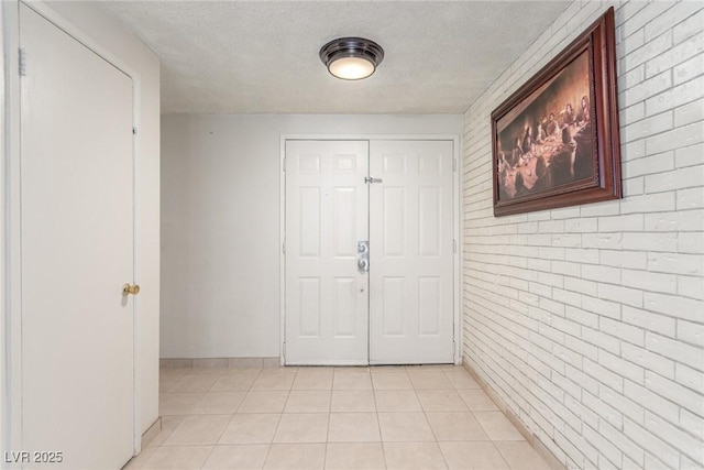 2254 Florence Ave, Las Vegas, NV 89119 - entryway featuring brick wall, light tile patterned floors, and a textured ceiling