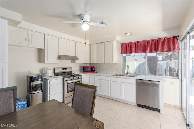 2254 Florence Ave, Las Vegas, NV 89119 - kitchen with stainless steel appliances, under cabinet range hood, a ceiling fan, white cabinetry, and light tile patterned flooring