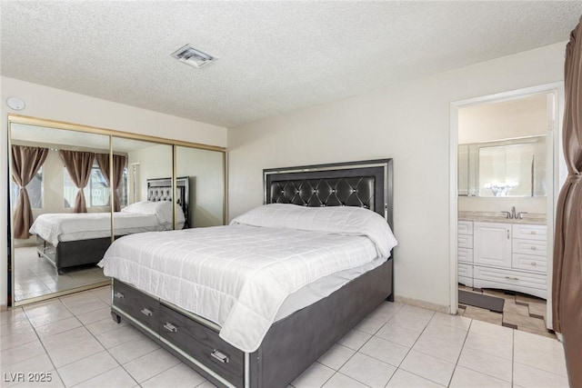 2254 Florence Ave, Las Vegas, NV 89119 - bedroom with a closet, light tile patterned floors, a textured ceiling, and ensuite bathroom