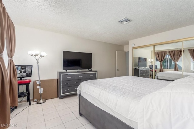 2254 Florence Ave, Las Vegas, NV 89119 - bedroom with a textured ceiling, a closet, and light tile patterned flooring