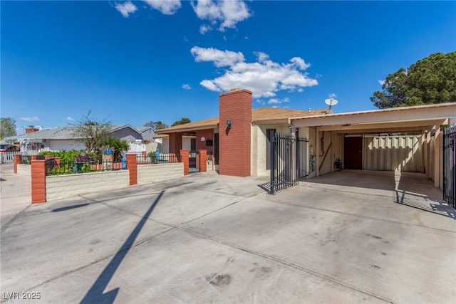 2254 Florence Ave, Las Vegas, NV 89119 - view of front of property with concrete driveway, a carport, stucco siding, a chimney, and a gate