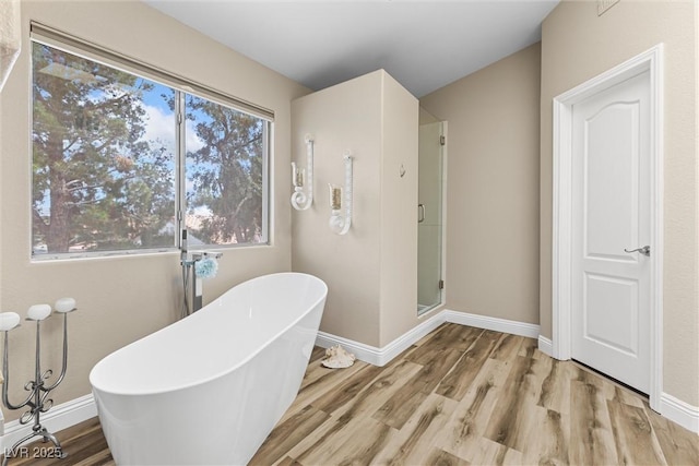 5452 Desert Spring Rd, Las Vegas, NV 89149 - bathroom featuring wood finished floors, a soaking tub, and a stall shower