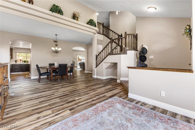 5452 Desert Spring Rd, Las Vegas, NV 89149 - entrance foyer featuring arched walkways, stairway, wood finished floors, a chandelier, and lofted ceiling