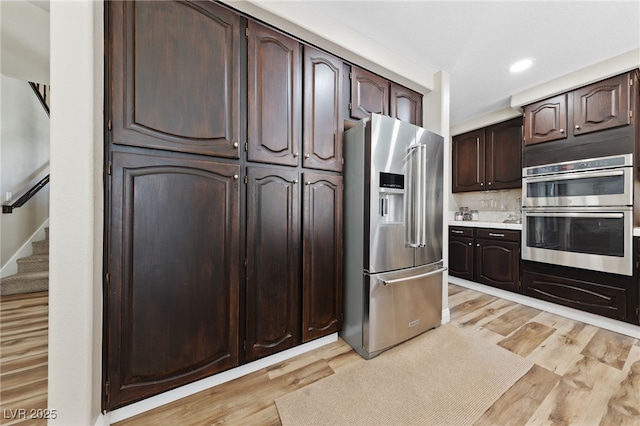 5452 Desert Spring Rd, Las Vegas, NV 89149 - kitchen featuring appliances with stainless steel finishes, light wood-type flooring, dark brown cabinetry, light countertops, and recessed lighting