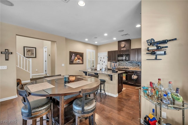 10312 Glimmering Star Dr, Las Vegas, NV 89178 - dining area with dark wood finished floors, recessed lighting, and stairway