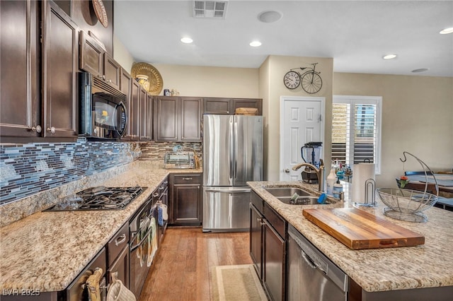 10312 Glimmering Star Dr, Las Vegas, NV 89178 - kitchen featuring stainless steel appliances, a kitchen island with sink, dark brown cabinetry, and recessed lighting