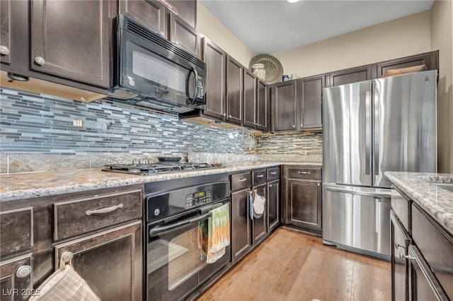 10312 Glimmering Star Dr, Las Vegas, NV 89178 - kitchen with black appliances, dark brown cabinets, light wood-style flooring, and tasteful backsplash