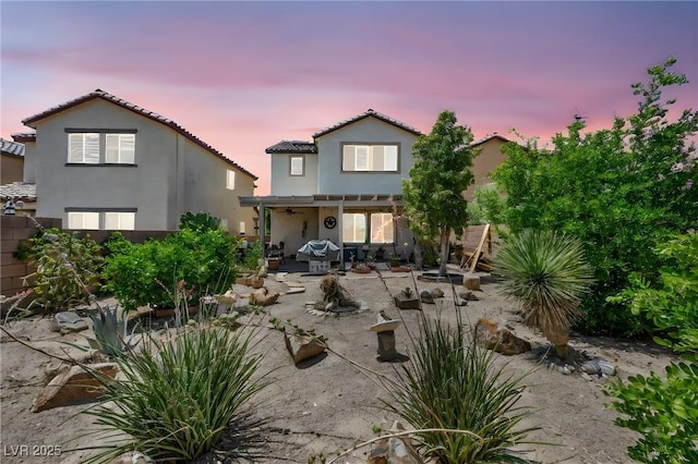 10312 Glimmering Star Dr, Las Vegas, NV 89178 - back of property at dusk featuring stucco siding, a tiled roof, a patio, and a ceiling fan
