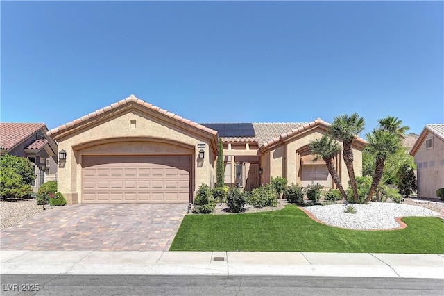 2605 Orchid Valley Dr, Las Vegas, NV 89134 - mediterranean / spanish house featuring solar panels, driveway, an attached garage, a front lawn, and stucco siding