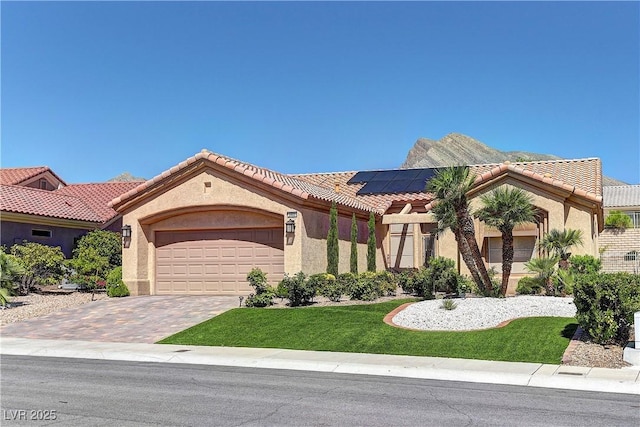 2605 Orchid Valley Dr, Las Vegas, NV 89134 - mediterranean / spanish-style home featuring an attached garage, solar panels, stucco siding, and a front yard