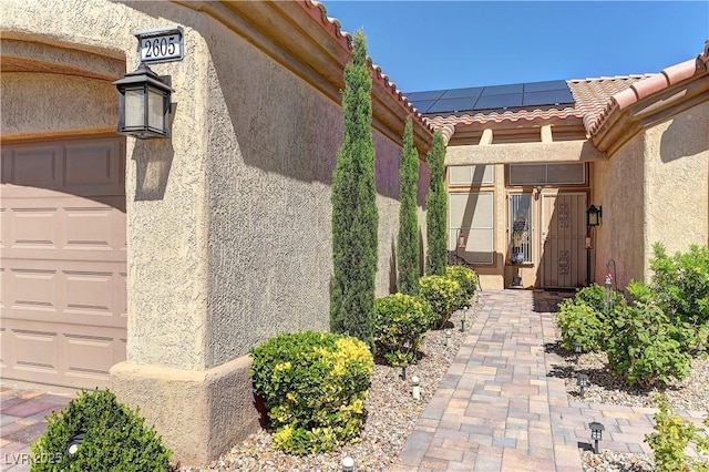 2605 Orchid Valley Dr, Las Vegas, NV 89134 - entrance to property with a tile roof, stucco siding, roof mounted solar panels, and a garage