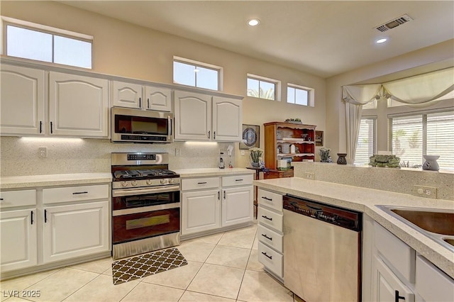 2605 Orchid Valley Dr, Las Vegas, NV 89134 - kitchen featuring appliances with stainless steel finishes, light tile patterned flooring, light countertops, white cabinets, and recessed lighting