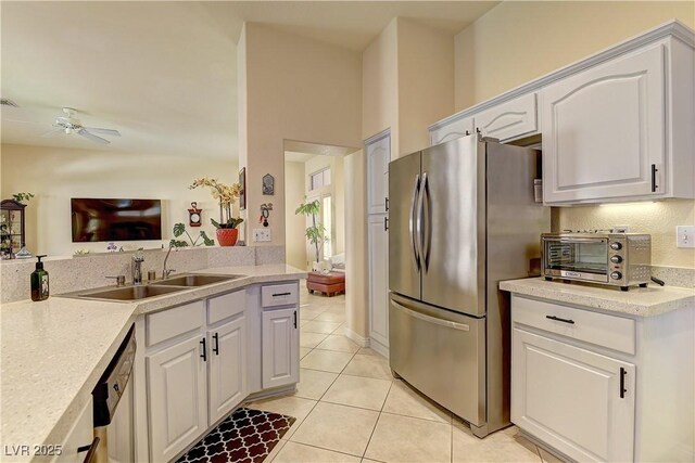 2605 Orchid Valley Dr, Las Vegas, NV 89134 - kitchen with stainless steel appliances, light tile patterned floors, light countertops, white cabinets, and a ceiling fan