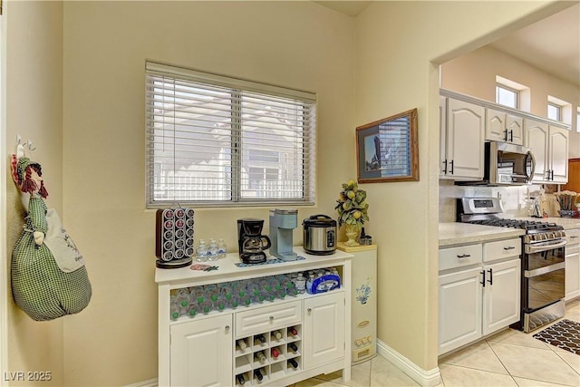 2605 Orchid Valley Dr, Las Vegas, NV 89134 - kitchen with stainless steel appliances, light countertops, light tile patterned flooring, and white cabinetry