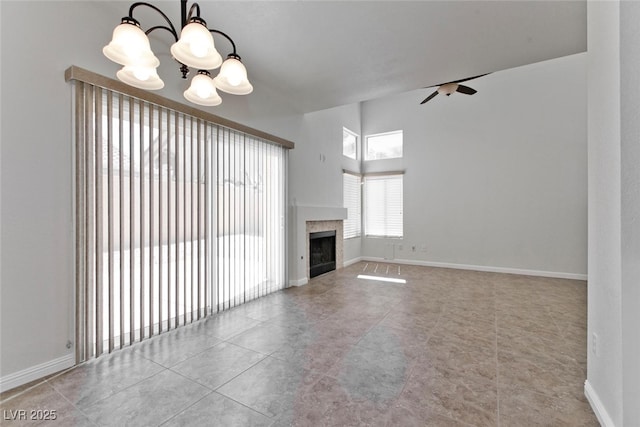1663 Cloister Ave, Henderson, NV 89014 - unfurnished living room with a chandelier, a ceiling fan, a fireplace, and tile patterned flooring