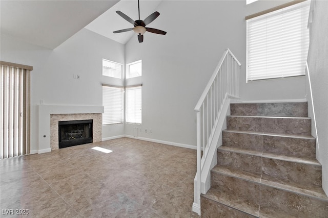 1663 Cloister Ave, Henderson, NV 89014 - unfurnished living room featuring stairs, a ceiling fan, high vaulted ceiling, and a tile fireplace