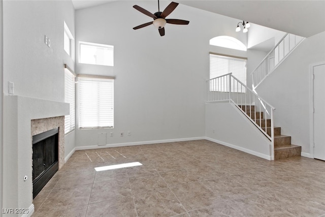 1663 Cloister Ave, Henderson, NV 89014 - unfurnished living room featuring high vaulted ceiling, a ceiling fan, stairway, healthy amount of natural light, and a fireplace