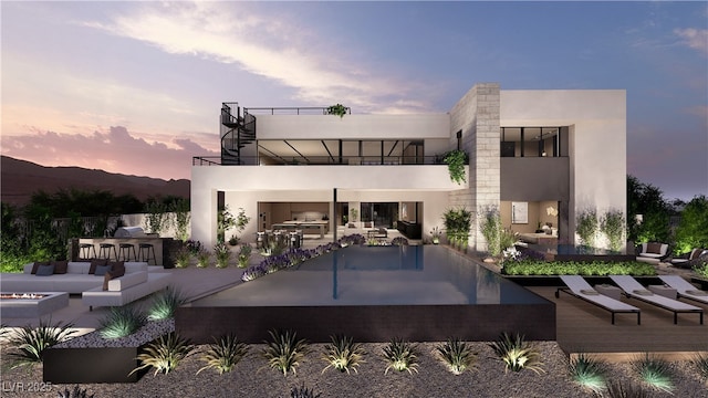 1516 Pleasant Bay Ct, Henderson, NV 89011 - back of house at dusk featuring an outdoor kitchen, a balcony, a patio, and stucco siding