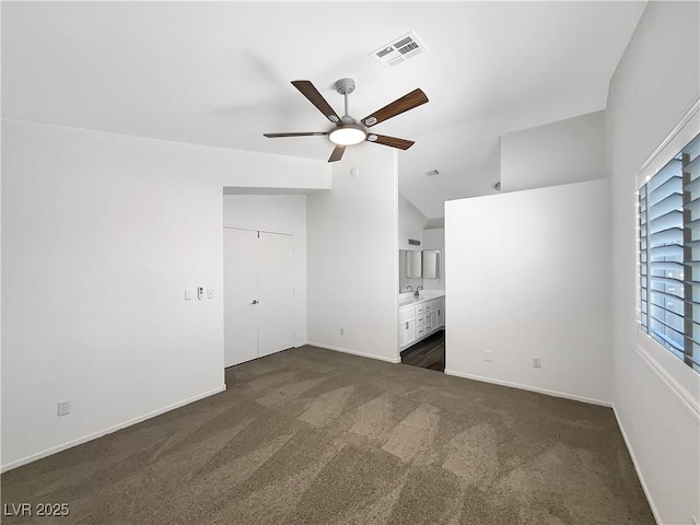6696 Merced Lake Dr, Las Vegas, NV 89156 - unfurnished bedroom featuring dark colored carpet, ensuite bath, vaulted ceiling, and ceiling fan