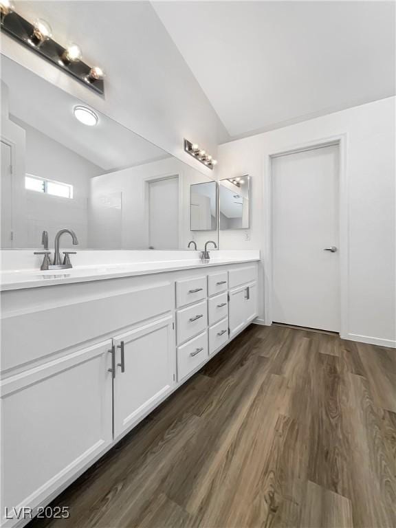 6696 Merced Lake Dr, Las Vegas, NV 89156 - bathroom with vaulted ceiling, double vanity, and wood finished floors